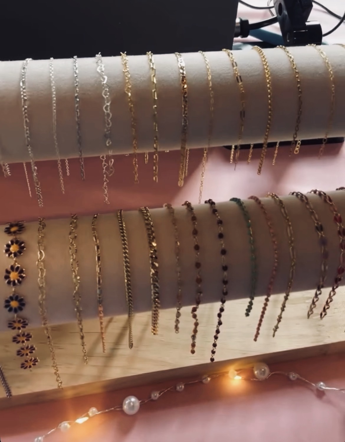 Display of gold, silver, and beaded permanent jewelry chains on rolls