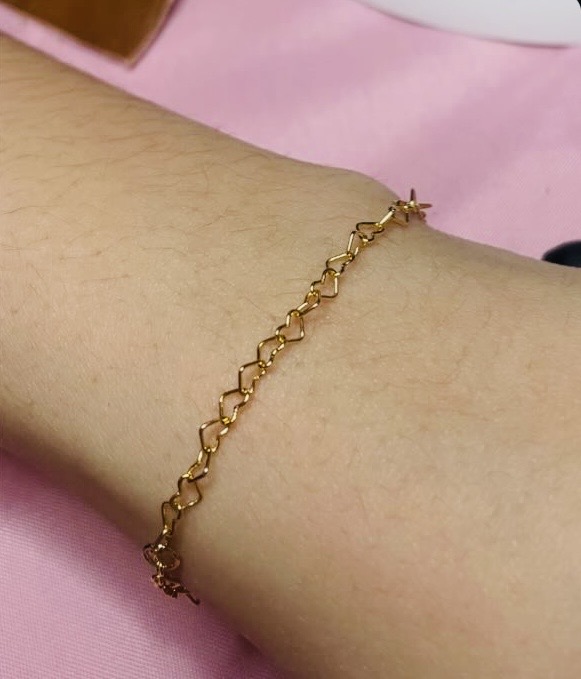 Gold heart link bracelet on a wrist